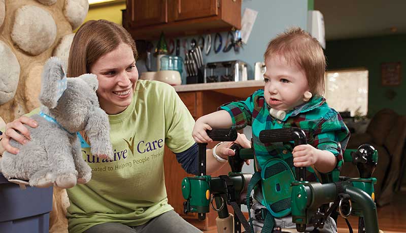 Young boy with walker working with female therapist