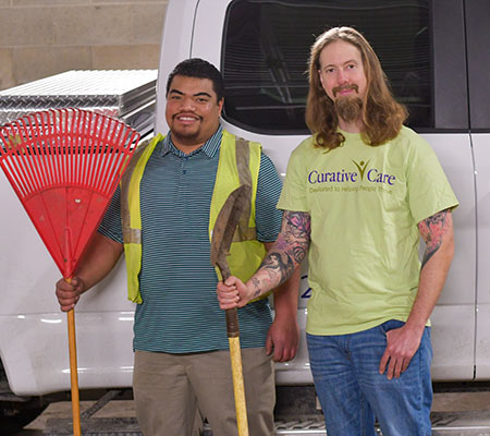 Mark and male supervisor holding landscape equipment