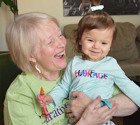 Molly being held by female therapist and smiling